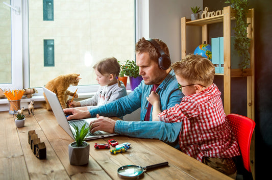 Work from home. Man works on laptop with children playing around. Family together with pet cat on table